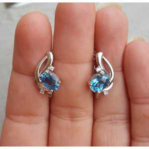 Silver earrings set with oval blue Topaz