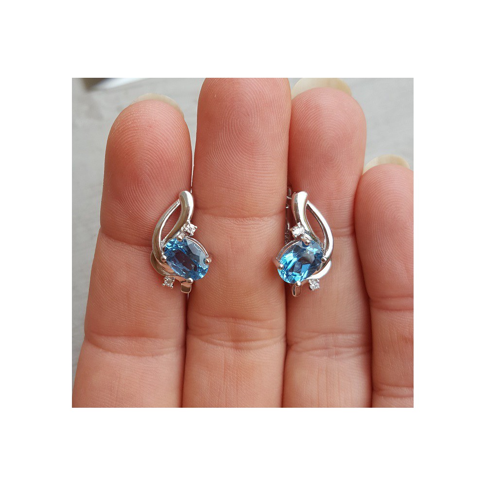 Silver earrings set with oval blue Topaz