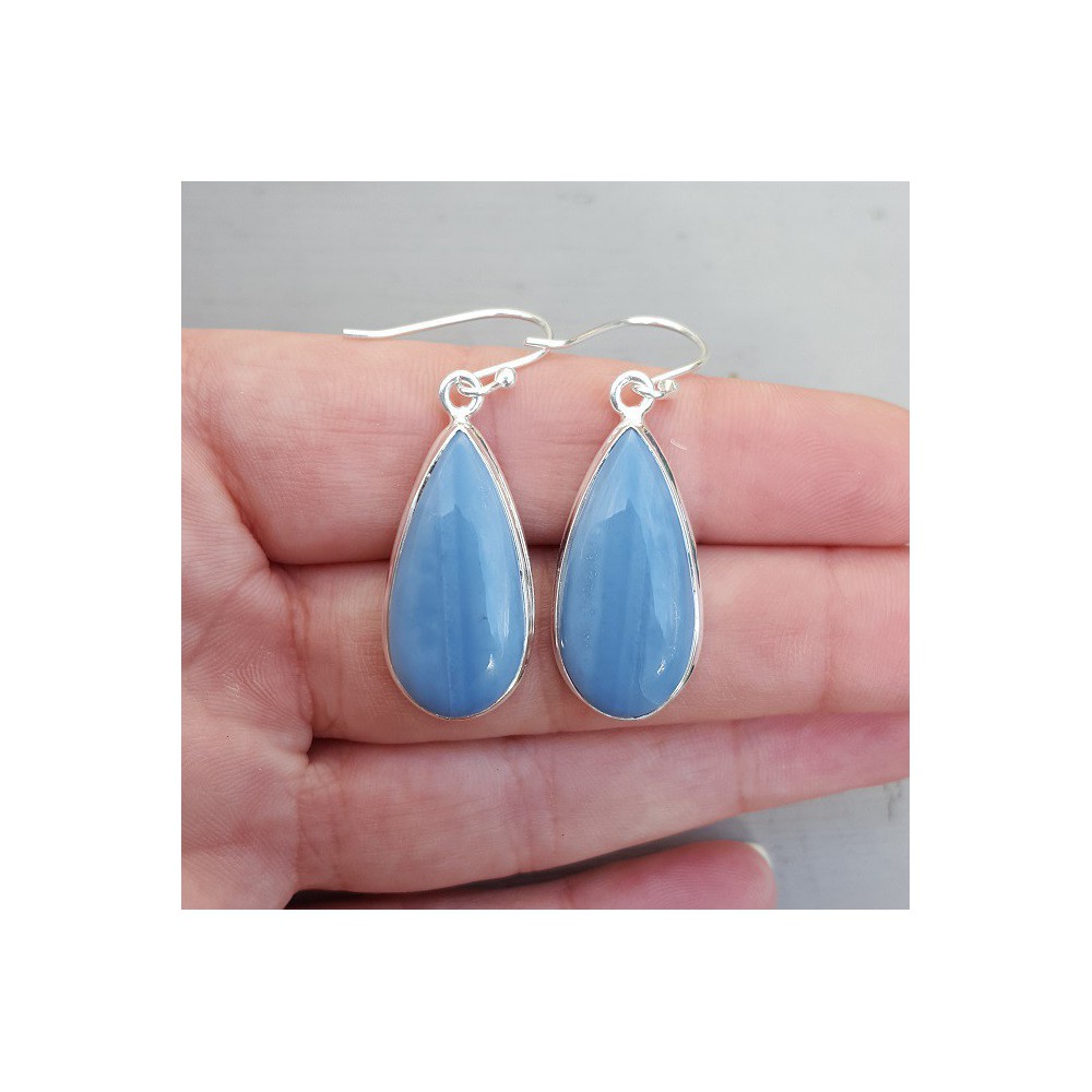 Silver earrings set with narrow teardrop shaped blue Opal