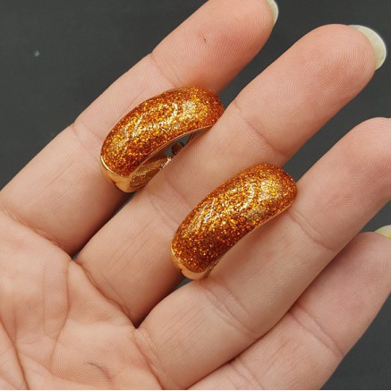 Gouden brede oranje glitter creolen