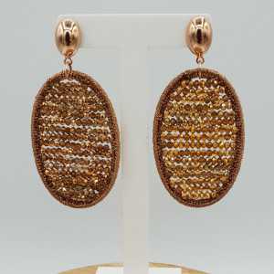Earrings with oval pendant made of silk thread and crystals
