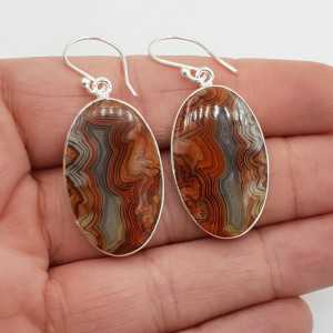 Silver earrings set with large oval Laguna Lace Agate