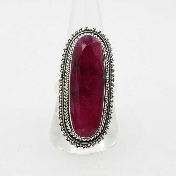 A silver ring set with an oval faceted Ruby in