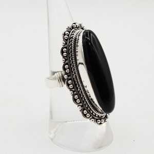 A silver ring set with black Onyx and a carved head