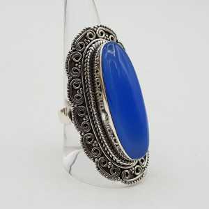 Ein silberner ring mit einem blauen Chalcedon und geschnitzten Köpfen