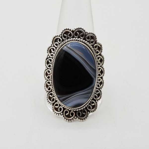 A silver ring with a black Botswana Agate stone and carved head, 20.5 mm