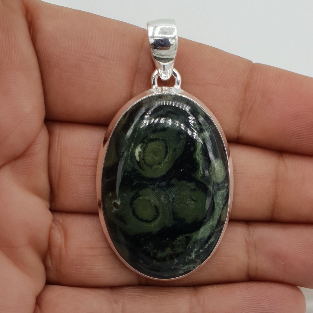 A silver pendant set with an oval Kambaba Jasper