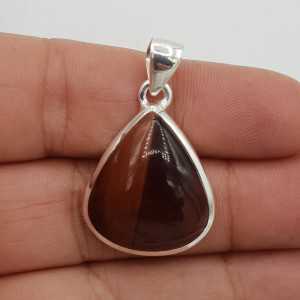 A silver pendant set with large teardrop shaped red tiger's eye
