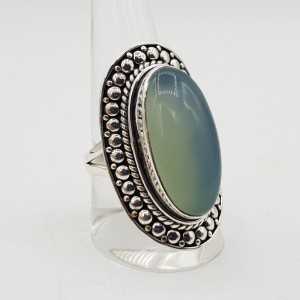 A silver ring set with an oval aqua Chalcedony