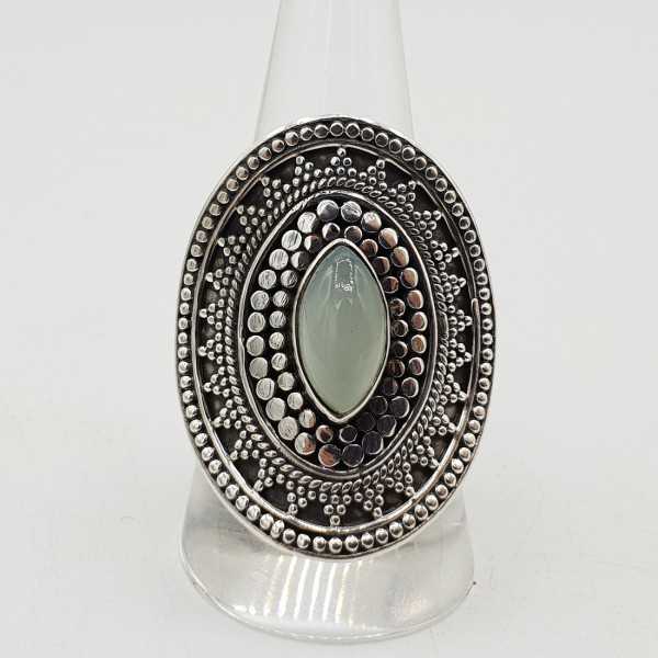 A silver ring set with a marquise aqua Chalcedony, and carved heads