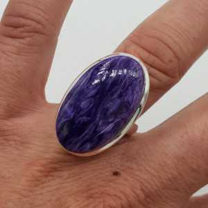 A silver ring set with an oval Charoiet 17 mm