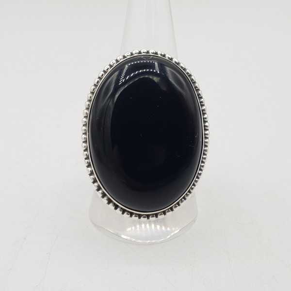 A silver ring set with a large oval-shaped black Onyx 19.5 mm